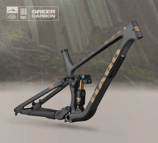 Greer Carbon Frameset in matte black/gold with 160mm travel & FOX FLOAT X2 Factory, shown on a forest-inspired background.