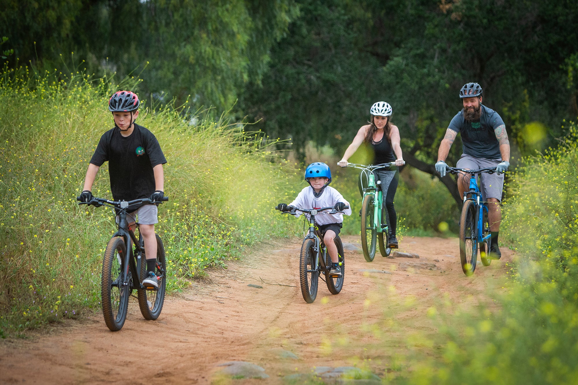 family riding bike on a dirt trail