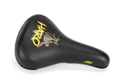 The black SloRide Railed Seat by Haro Bikes features a stylish graphic of a BMX stunt with HARO in yellow letters. It has an ergonomic design, nylon cover, and enhances performance and style.