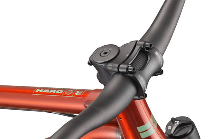 Close-up of a black handlebar and stem on a shiny red Steel Reserve bike frame against a white background.