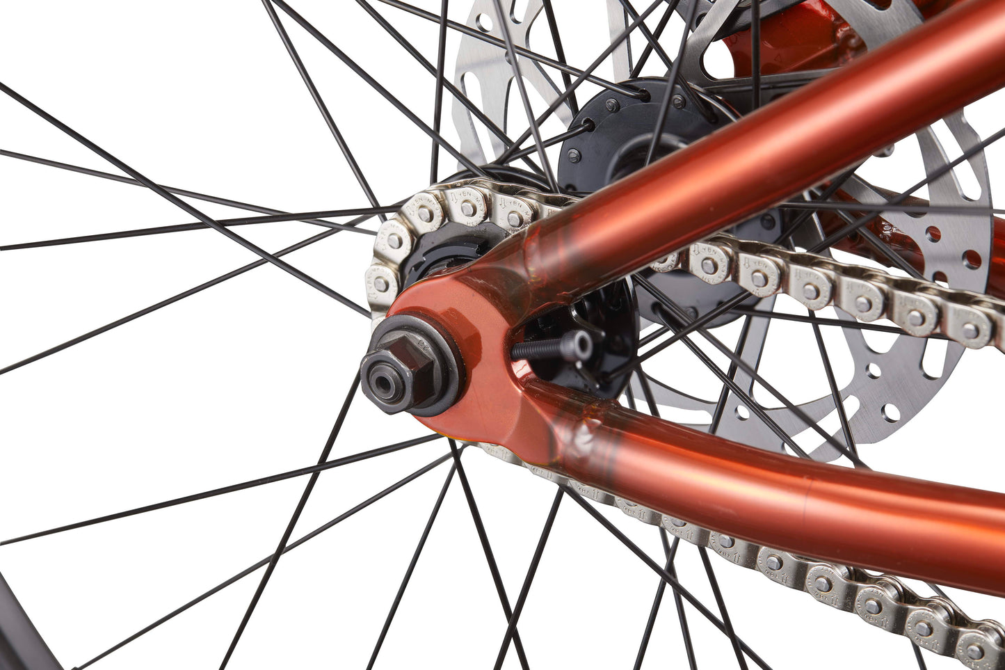Close-up of the Steel Reserve’s rear wheel, highlighting its chromoly frame, chain, spokes, and disc brake against white.