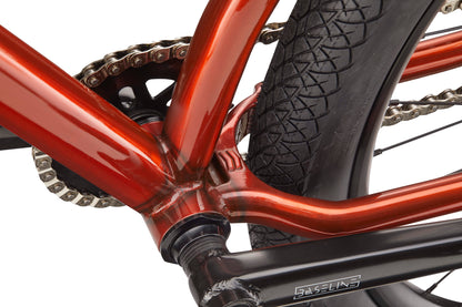 Close-up of a red Steel Reserve frame, chain, and rear tire with visible tread, highlighting the crank arm and chainring.