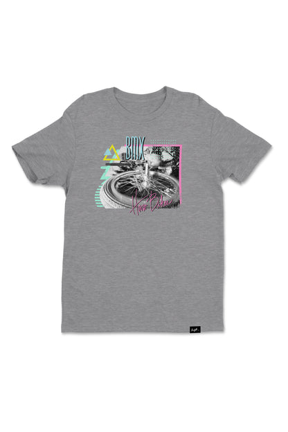 The Windy Osborn Backside Shirt from Haro Bikes is a gray crew neck tee with geometric shapes and a monochrome fountain image. Made from 100% combed ring-spun cotton, it features pastel colors including pink, teal, yellow, and text BTS and Now Belong.