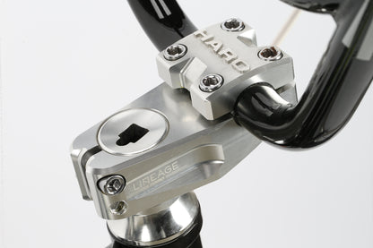 Close-up of the Haro Bikes DMC 24. A silver stem connects to black freestyler bars, with HARO engraved on top and LINEAGE on the side. Four bolts hold the handlebars, and a visible top cap completes the look.