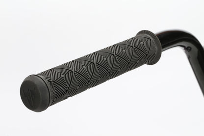 Close-up of a Dana bicycle handlebar by Haro Bikes, showing a textured gray grip with a geometric pattern. The cylindrical grip extends from the sleek black metal handlebar, part of a sturdy chromoly frame, against a plain white background.