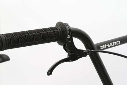 Close-up of a Leucadia black handlebar with textured grip and brake lever, ideal for neighborhood cruising. Haro Bikes and its logo are displayed on the handlebar. The sleek design stands out beautifully against a neutral background.