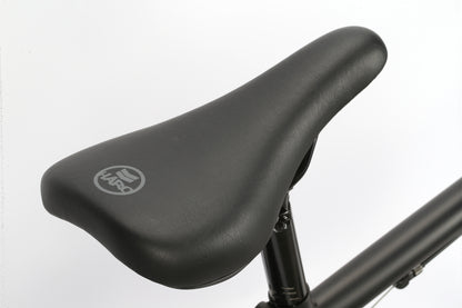 Close-up of a black Leucadia bicycle seat by Haro Bikes, ready to cruise through the neighborhood, mounted on a bike frame against a plain white background.