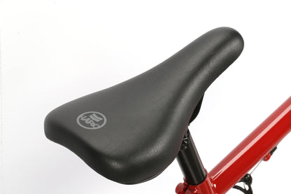 Close-up of a Haro Bikes Leucadia saddle with a black seat and logo, ready for adventure atop a vibrant red frame. Ideal for exploring the neighborhood or making an entrance at the skatepark.