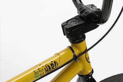 Close-up of a yellow BMX bike frame with Haro Bikes branding, ideal for neighborhood rides. The image highlights the handlebar connection and part of the frame, emphasizing the design and details of the Leucadia by Haro Bikes.