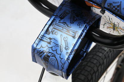 Close-up of Haro Bikes Radical Rick 24 BMX bike featuring a blue, illustrated fender with Radical Rick cartoons and tools. The black handlebars and tire contrast with a white background, embodying Damian Fultons energetic style.