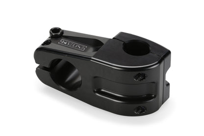 The Baseline Top Load CNC Stem by Haro Bikes is crafted from 6061 aluminum with a sleek black anodized finish and rounded edges. It features bolt holes, an engraved logo on top, and a clamping mechanism for securely attaching handlebars to the bicycle fork.