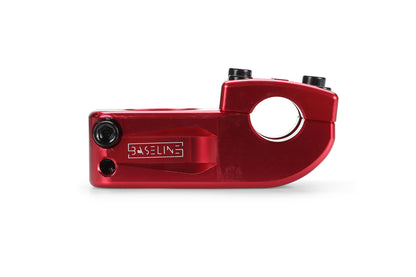 The Haro Bikes Baseline Top Load CNC Stem in red, made from CNC-machined 6061 aluminum, features a stylish design with bolt holes for easy attachment and an engraved brand logo. It is elegantly displayed against a white background.